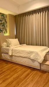 a large bed in a bedroom with wooden floors at Two Bedroom Apartment at The Nove, Nuvasa Bay, Nongsa 719 in Nongsa