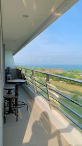 a balcony with a table and chairs and a view of the ocean at Two Bedroom Apartment at The Nove, Nuvasa Bay, Nongsa 719 in Nongsa