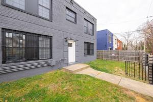 a gray house with a white door and a yard at MODERN Updated Rare 2BR Condo in Washington