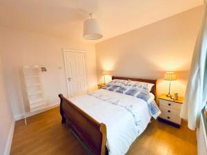 a bedroom with a large bed with a wooden floor at Beach Park House in Downings