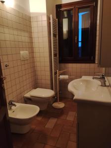 een badkamer met 2 wastafels en een toilet bij B&B del Fernè in Monte Ombraro