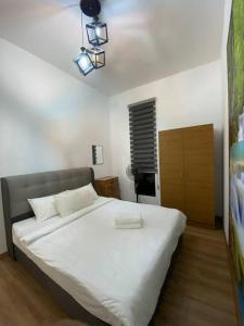 a bedroom with a large white bed in a room at Modern Lux Suite, The Cove Hillside Residence in Ipoh