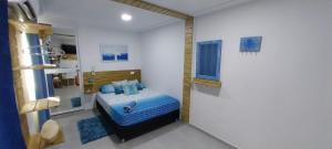 ein Schlafzimmer mit einem blauen Bett in einem Zimmer in der Unterkunft POSADA ALEENY in Providencia
