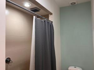 y baño con ducha y cortina de ducha. en Amplia habitación a 5 minutos del aeropuerto en Cancún