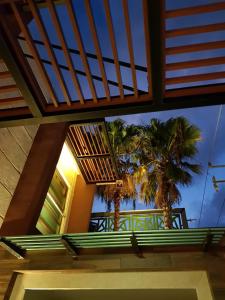 Casa con balcón con palmeras en el fondo en Amplia habitación a 5 minutos del aeropuerto en Cancún