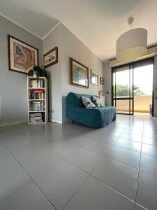 ein Wohnzimmer mit einem blauen Sofa auf einem Fliesenboden in der Unterkunft L'Arciunesa in Riccione