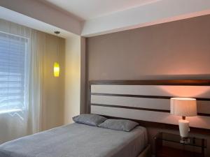 1 dormitorio con cama, lámpara y ventana en Amplia habitación a 5 minutos del aeropuerto en Cancún