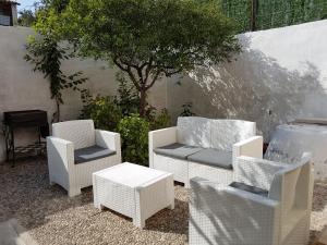 een groep stoelen en een tafel en een boom bij Guest House San Vito Lo Capo in San Vito lo Capo