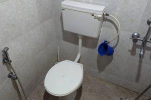 een badkamer met een wit toilet in een stal bij Sree Sai Guruvayoor in Guruvāyūr