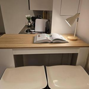 an open book sitting on a desk with a lamp at One bedroom apartement with terrace and wifi at Lisse in Lisse