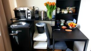 a black desk with a microwave and a refrigerator at Amor Guesthouse in Amsterdam