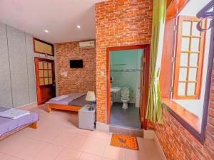 a living room with a brick wall and a bathroom at Hoàng Sơn's Home in Can Tho