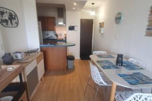 cocina y sala de estar con mesa y sillas en Appartement front de mer - 6198, en Soulac-sur-Mer