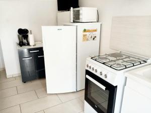 a kitchen with a white refrigerator and a stove at Maison d'une chambre avec jardin clos et wifi a Tonnay Charente in Tonnay-Charente