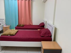 two twin beds in a room with a colorful curtain at Stanley Hostel in Dubai