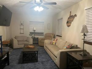 a living room with two couches and a ceiling fan at Ruby’s Retreat in Mount Gay