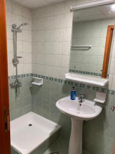 a bathroom with a sink and a shower with a mirror at Stanley Hostel in Dubai