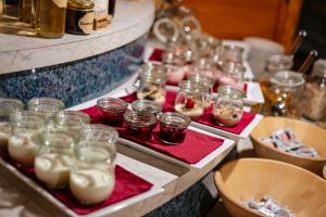 a buffet filled with jars of food on red napkins at Alpen Gasthof Apartments Hohe Burg in Trins +115 photos