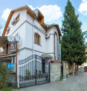 una casa blanca con una puerta negra en Venesa, en Tiflis