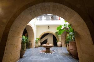 an archway in a building with a fountain in a courtyard at Riad Dar Nor in Essaouira
