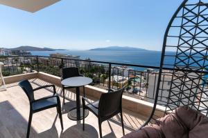 einen Balkon mit einem Tisch, Stühlen und Meerblick in der Unterkunft Blissful Apartments in Sarandë