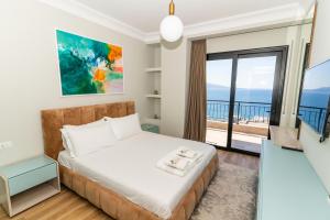 a bedroom with a bed and a balcony at Blissful Apartments in Sarandë