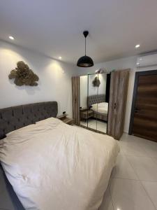 une chambre avec un grand lit et un miroir dans l'établissement serenityrecidencesitesi, à Alanya