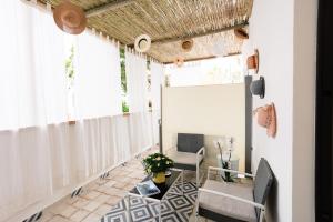 uma varanda com cortinas brancas e uma mesa e cadeiras em MAISON SAINT MICHAEL em Capri