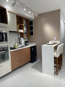 una cocina con electrodomésticos blancos y armarios marrones en Beca02/Copacabana/Vista Lateral Mar/Vaga, en Río de Janeiro
