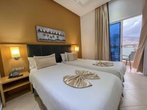 得土安Prestige Hotel & Spa的有两张床和一扇窗户的酒店房间