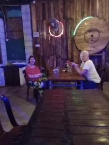 deux personnes assises à une table dans un bar dans l'établissement ROCK VIEW RELAX Inn, à Sigirîya