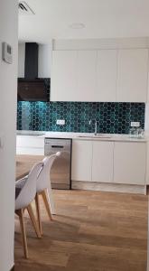 a kitchen with white cabinets and a white chair at Apartament centre casaPat in Xàtiva