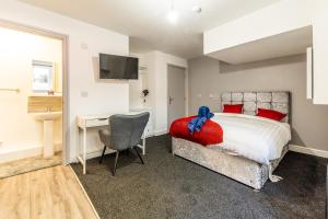 a bedroom with a bed and a desk and a chair at Stay Sleep Rest - Derby Road in Nottingham