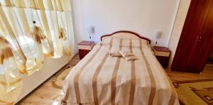 een slaapkamer met een bed, 2 tafels en een raam bij Pensiunea Miana in Gîrcina de Jos
