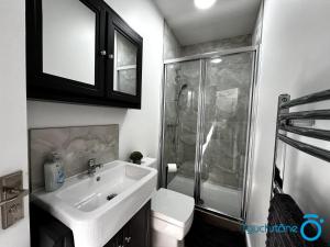 La salle de bains est pourvue d'un lavabo, d'une douche et de toilettes. dans l'établissement Beautiful Apartment for solo and couple travellers, à Sheldon