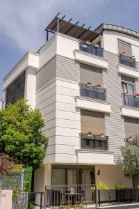 a tall white building with balconies on a street at Loi Suite in Antalya