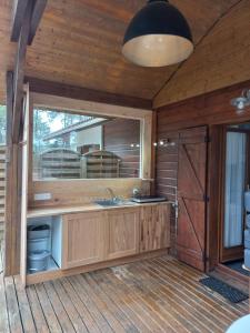 eine Küche mit einem Waschbecken und einem Spiegel in der Unterkunft CHALET B NATURISTE NAEVA in Le Porge