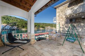 eine Veranda mit einem Stuhl, einem Tisch und Wasser in der Unterkunft Studio Apartments Klara and Rio in Stomorska