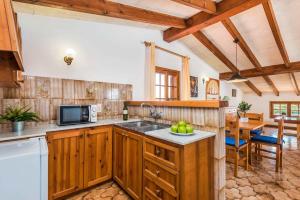 a kitchen with wooden cabinets and a table in a room at Villa Jalima in Son Carrio