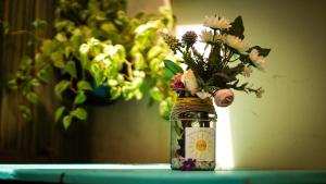a jar filled with flowers sitting on a table at Canto das Laranjeiras Beach Club Guaiuba in Guarujá
