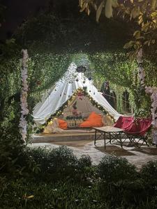 Ấp Long Lâm的住宿－Suối Đá F-Glamping，花园内带床的白色帐篷