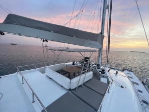 a white boat in the water with a sunset at "Marea" Sunreef 62 Catamaran with Crew all inclusive in Isla Wichitupo Grande