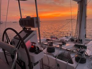 un bateau dans l'océan avec un coucher de soleil en arrière-plan dans l'établissement "Marea" Sunreef 62 Catamaran with Crew all inclusive, à Isla Wichitupo Grande