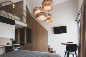a bedroom with a bed and two chandeliers at Wood (Forestia) in Theux