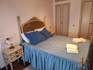 a bedroom with a bed with blue sheets and blue pillows at Casa das Floreiras - City Center Apartment in Horta