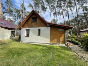 una pequeña casa en un patio con árboles en el fondo en Sunny Home Turawa, en Turawa