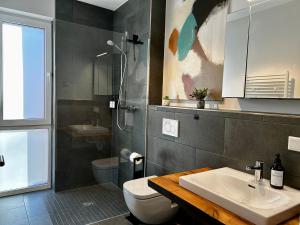 a bathroom with a sink and a toilet and a shower at Cozy Suite am Möhnesee in Möhnesee
