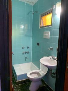 a bathroom with a toilet and a sink and a shower at HOSTAL EL REY in Cafayate