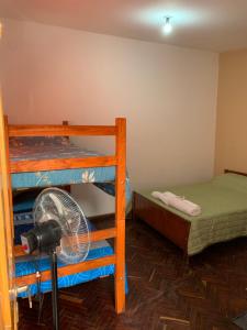 Zimmer mit 2 Etagenbetten und einem Ventilator in der Unterkunft HOSTAL EL REY in Cafayate