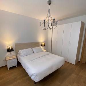 a bedroom with a large white bed and a chandelier at Apartament centre casaPat in Xàtiva